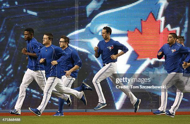 Miguel Castro of the Toronto Blue Jays and Aaron Loup and Brett Cecil and Jeff Francis and Roberto Osuna jog in the outfield during batting practice...