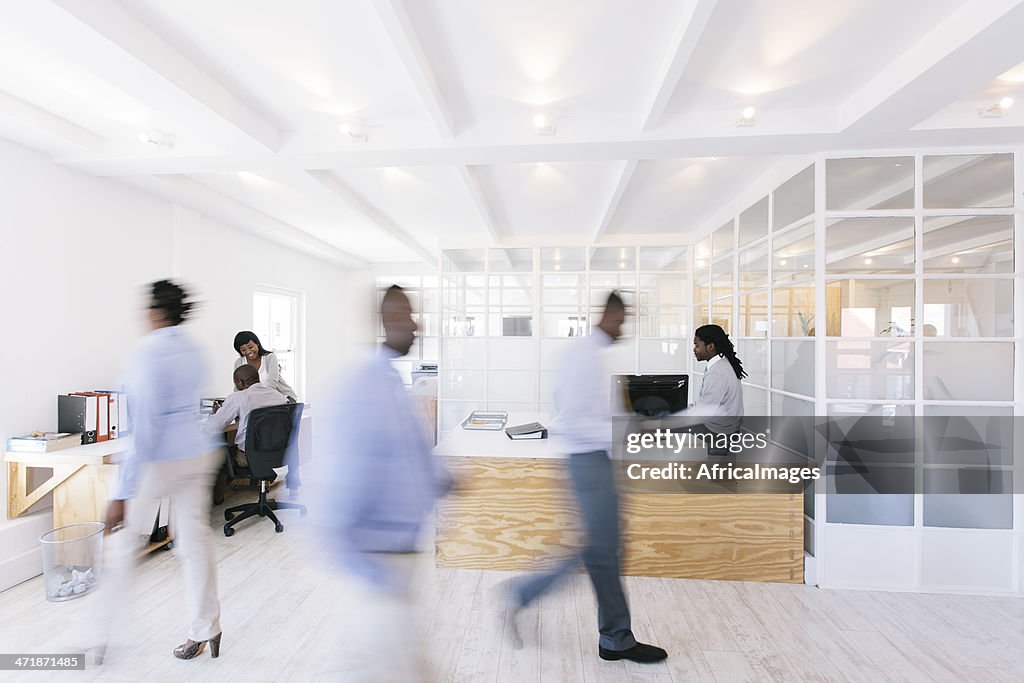Busy African office with people walking around.