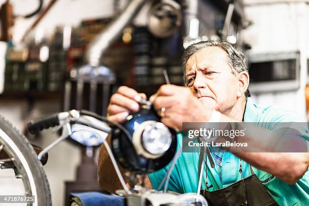 Senior mechanic fixing a motorcycle