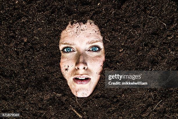 portrait of woman who is buried in a garden - woman mud stock pictures, royalty-free photos & images