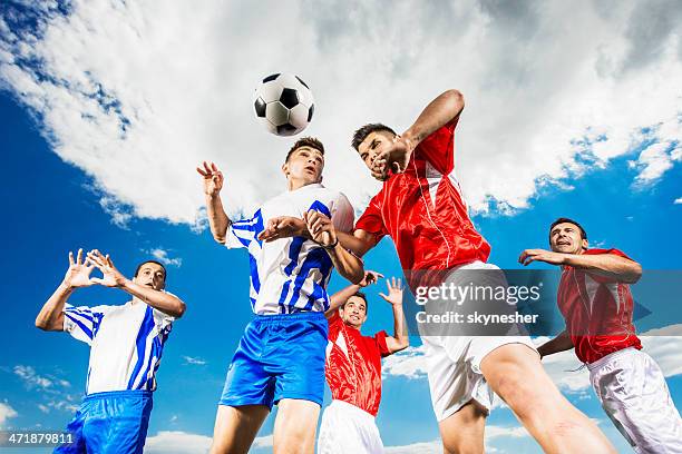 joueurs de football en direction de la balle contre le ciel. - heading the ball photos et images de collection