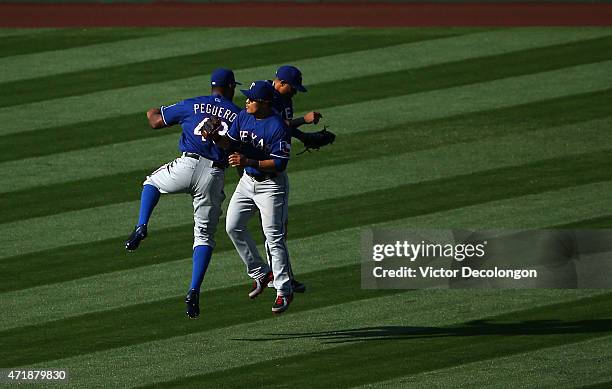 Carlos Peguero, Shin-Soo Choo and Leonys Martin of the Texas Rangers celebrate after their 5-4 win against the Los Angeles Angels of Anaheim in 11...