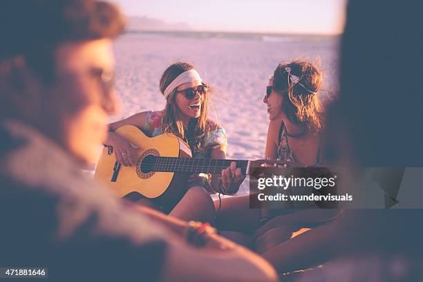mädchen spielt gitarre für ihre freunde bei beachparty - girl beach sunset stock-fotos und bilder