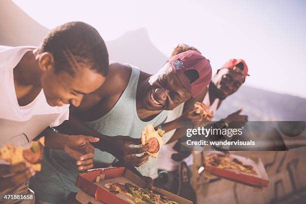 happy adolescent friends laughing together while sharing pizza - pizza humour stock pictures, royalty-free photos & images