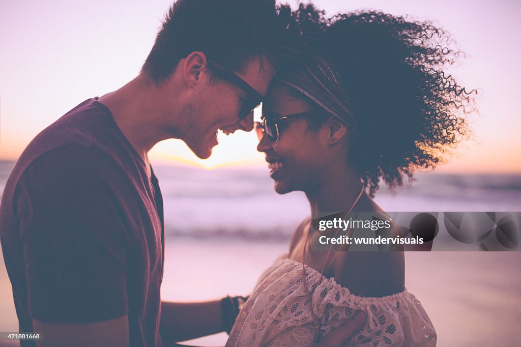 Mixed race couple sharing a romantic moment at sunset