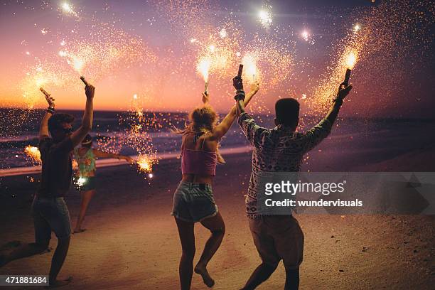 amigos corriendo en la playa y fuegos artificiales - fiesta en la playa fotografías e imágenes de stock