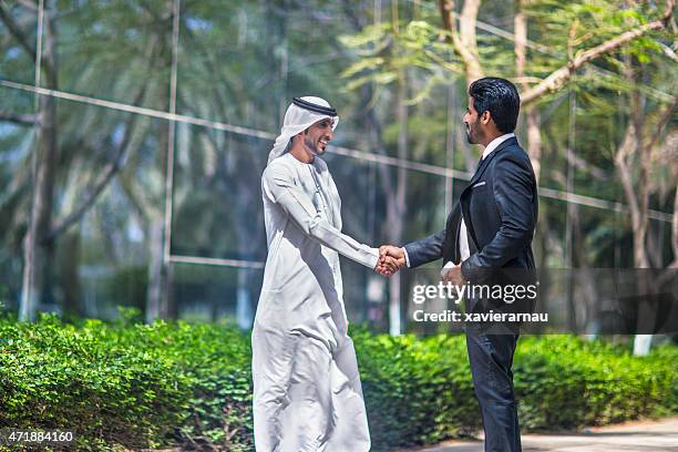 middle eastern businessmen shaking hands - arab businessman stock pictures, royalty-free photos & images