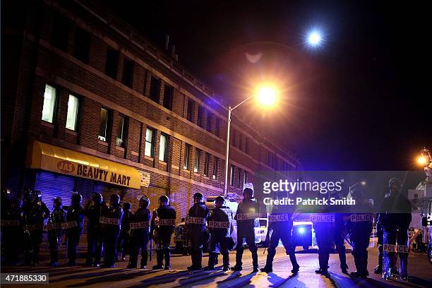 Police in riot gear stand on on the street after Baltimore authorities released a report on the death of Freddie Gray on May 1, 2015 in Baltimore,...