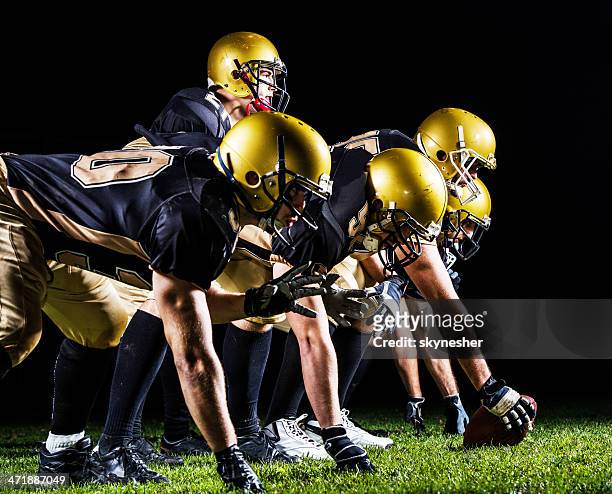 american football players lining up. - quarterback stockfoto's en -beelden