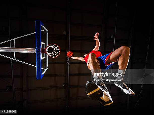 below view of a basketball player slam dunking the ball. - basketball shoe stock pictures, royalty-free photos & images