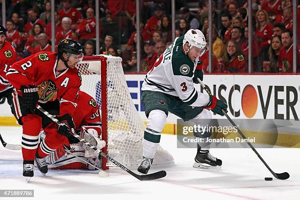 Charlie Coyle of the Minnesota Wild tries to get a shot off as Duncan Keith of the Chicago Blackhawks defends in Game One of the Western Conference...