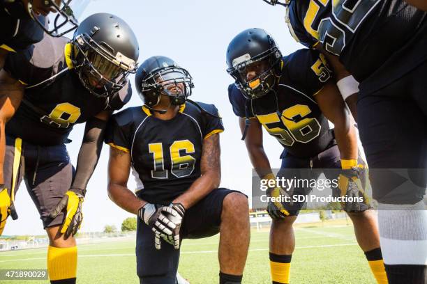 football team discussing strategy during game - team huddle stock pictures, royalty-free photos & images