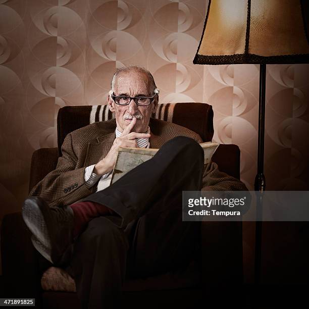 old man in living room - grumpy old man stock pictures, royalty-free photos & images