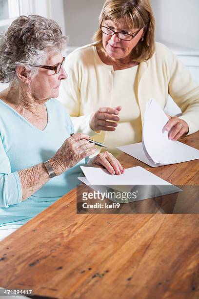 elderly woman reading paperwork - signing will stock pictures, royalty-free photos & images