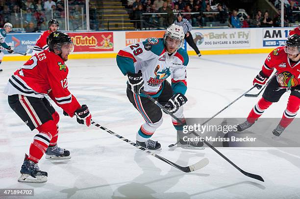 Miles Koules of Portland Winterhawks checks Leon Draisaitl of Kelowna Rockets during overtime of game 5 of the Western Conference Final on May 1,...