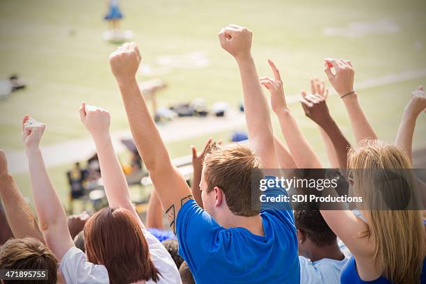 happy sports fans cheering and celebrating in stadium stands - crowd cheering outside stock pictures, royalty-free photos & images