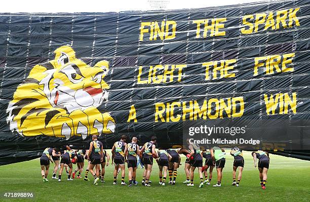 Tigers players walk under their banner during the round five AFL match between the Richmond Tigers and the Geelong Cats at Melbourne Cricket Ground...