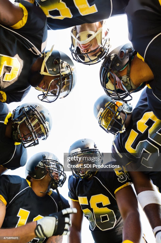 Football team huddling together during game time out