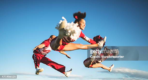 jumping on mid air - cheerleaders team with pon-pon - teen cheerleader 個照片及圖片檔