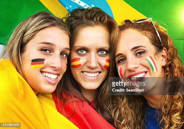italienische, deutsche und spanische fans.  brasilianische flagge im hintergrund. - faces of a nation stock-fotos und bilder