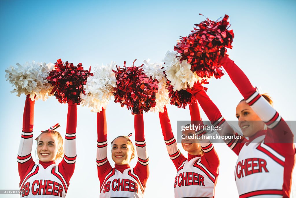 Happiness cheerleaders posing with pon-pon and arm raised