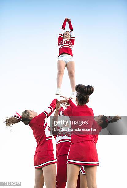 cheerleader throw-up-mädchen in der luft - human pyramid stock-fotos und bilder