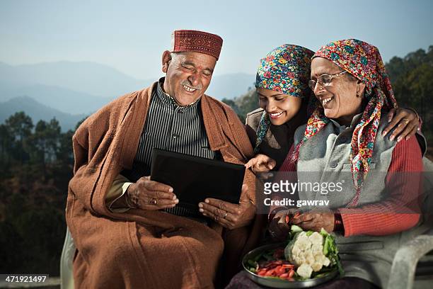 people of himachal pradesh: senior man using laptop with family. - himachal pradesh stockfoto's en -beelden