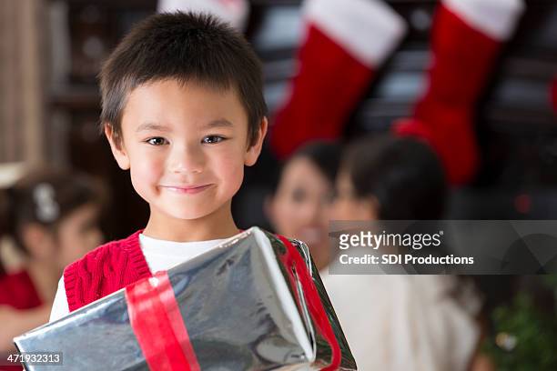 preschool age asian boy opening christmas presents with family - kid stocking stock pictures, royalty-free photos & images