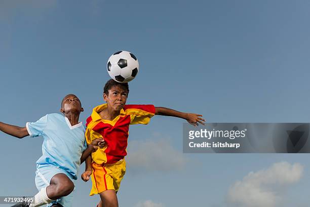 two young boys playing football - header stockfoto's en -beelden
