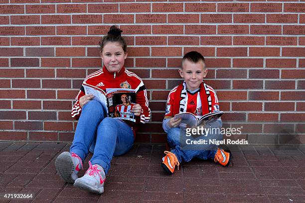 Young Sunderland supporters read the match-day programs prior to the Barclays Premier League match between Sunderland and Southampton at Stadium of...