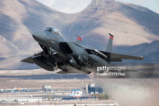 f-15e strike eagle flying past mountains - united states airforce stockfoto's en -beelden