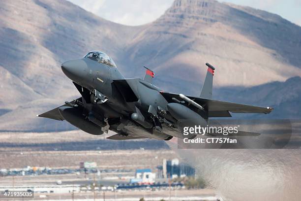 f-15e strike eagle flying past mountains - us air force stock pictures, royalty-free photos & images