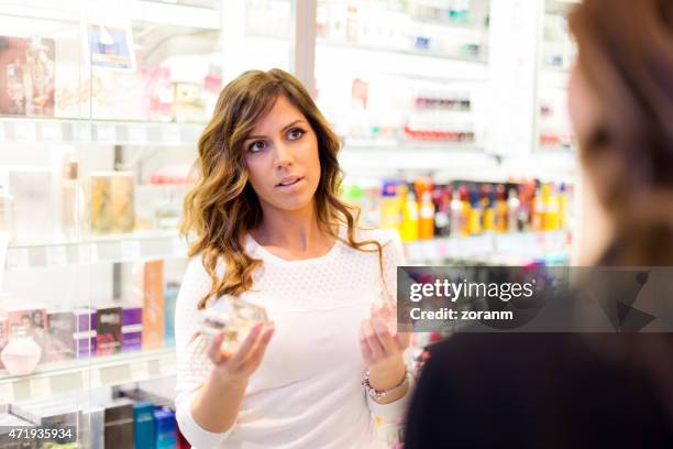 frauen sie parfume in shopping mall - cosmetic sales woman stock-fotos und bilder