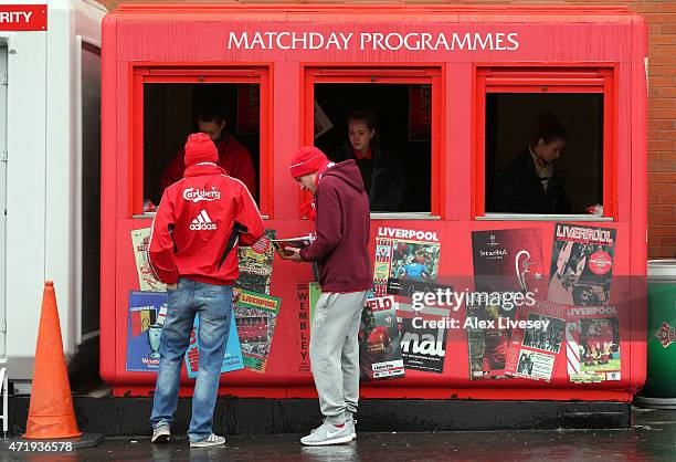 Supporters buy programmes prior to the Barclays Premier League match between Liverpool and Queens Park Rangers at Anfield on May 2, 2015 in...