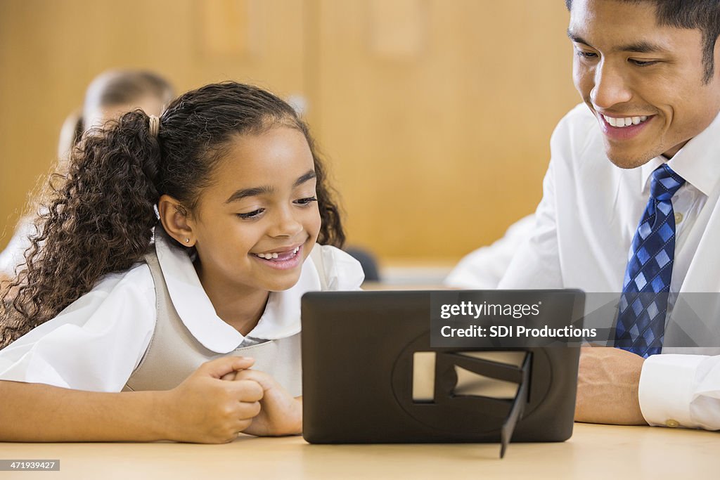 Private elementary school student using digital tablet device in classroom