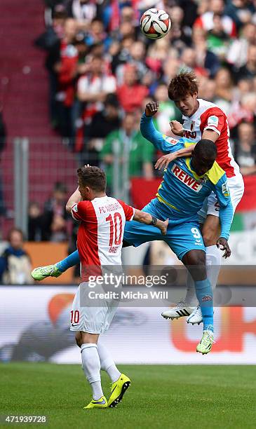 Anthony Ujah of Koeln and Jeong-Ho Hong of Augsburg jump for a header during the Bundesliga match between FC Augsburg and 1. FC Koeln at SGL Arena on...