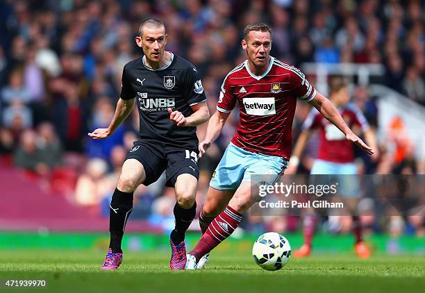 Kevin Nolan of West Ham United and David Jones of Burnley during the Barclays Premier League match between West Ham United and Burnley at the Boleyn...