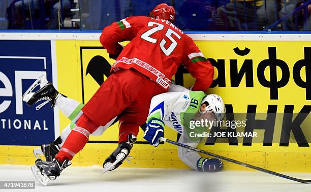 Oleg Yevenko of Belarus tackles down Slovenia's Miha Verlic during the group B preliminary round ice hockey match Belarus vs Slovenia of the IIHF...