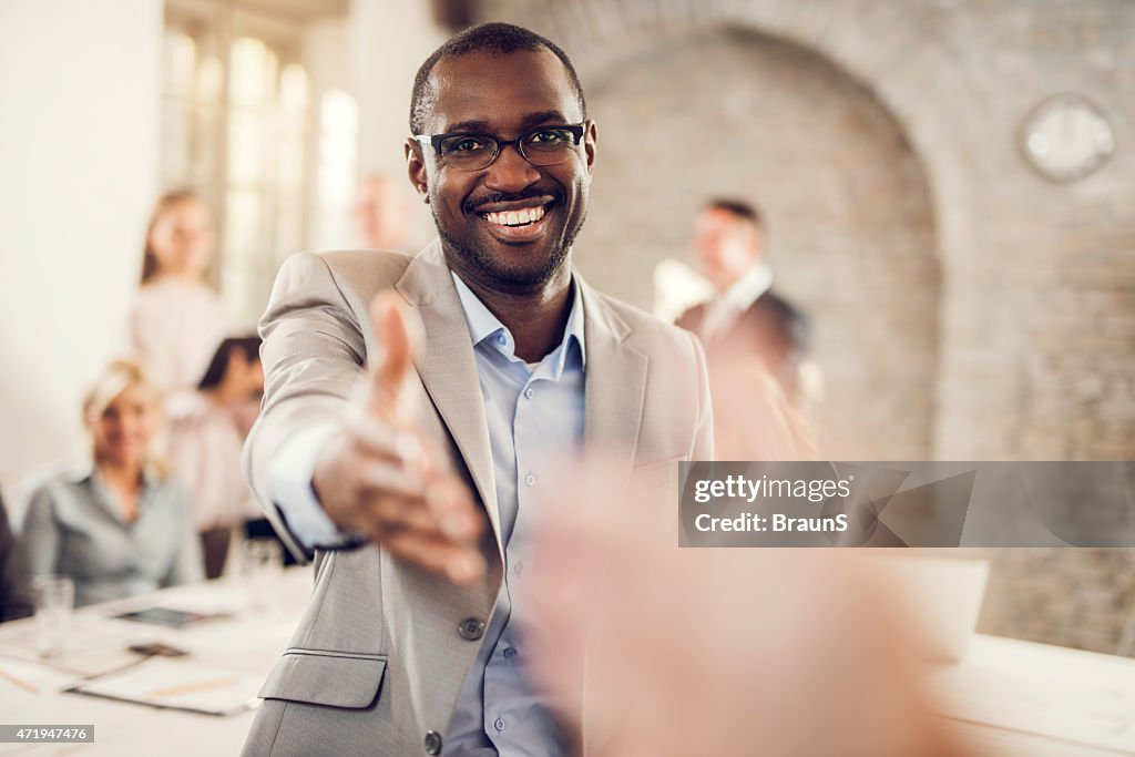 Happy African American businessman offering a handshake.
