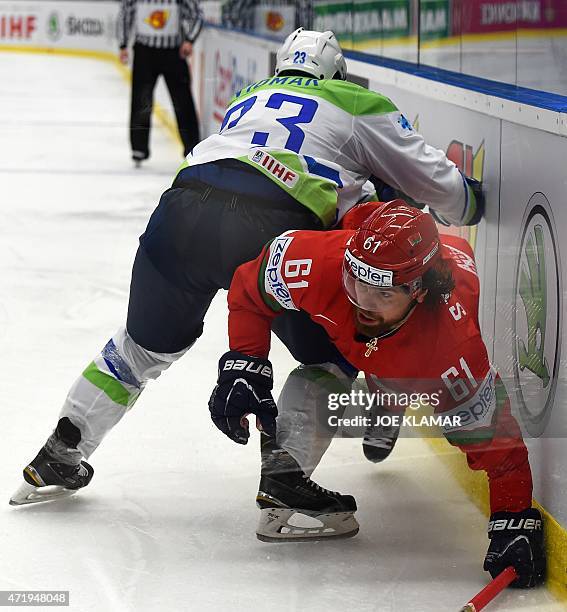 Slovenia's Luka Vidmar tackles Andrei Stepanov of Belarus during the group B preliminary round ice hockey match Belarus vs Slovenia of the IIHF...