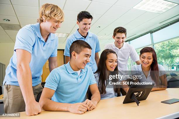 High School Students Wearing Uniforms Working With Technology In Class ...