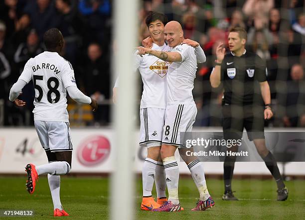 Sung-Yueng Ki of Swansea City celebrates scoring his team's second goal with his team mate Jonjo Shelvey and Modou Barrow during the Barclays Premier...