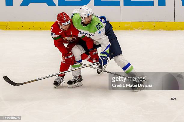 Alexei Kalyuzhny of Belarus and Sabahudin Kovacevic of Slovenia battle for the puck during the IIHF World Championship group B match between Belarus...
