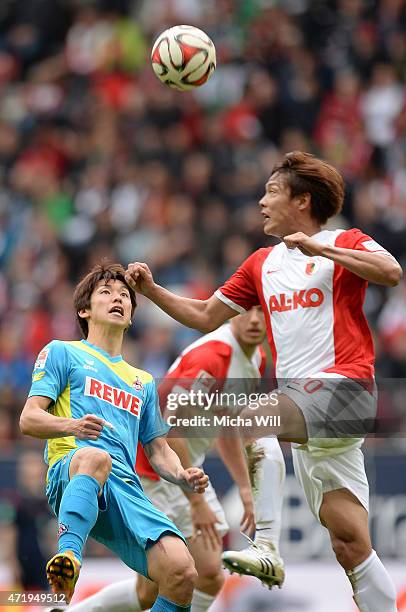 Yuya Osako of Koeln and Jeong-Ho Hong of Augsburg jump for a header during the Bundesliga match between FC Augsburg and 1. FC Koeln at SGL Arena on...