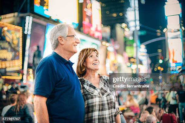 senior couple in times square new york - broadway manhattan stockfoto's en -beelden