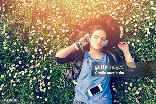 adolescente disfruta de la música en el parque - girls sunbathing fotografías e imágenes de stock