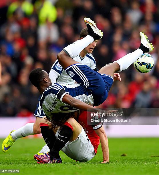 Saido Berahino of West Brom lands on Daley Blind of Manchester United as they battle for the ball during the Barclays Premier League match between...