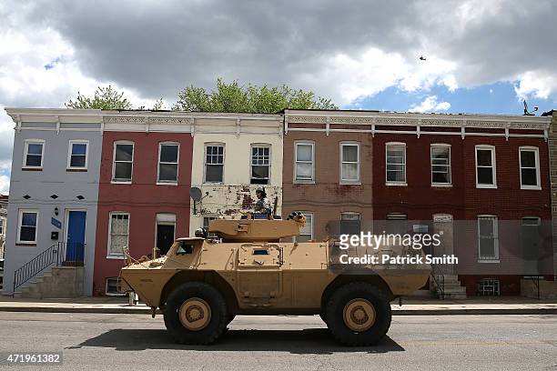National Guard armored vehicles drive near the Gilmor Houses housing project a day after Baltimore authorities released a report on the death of...