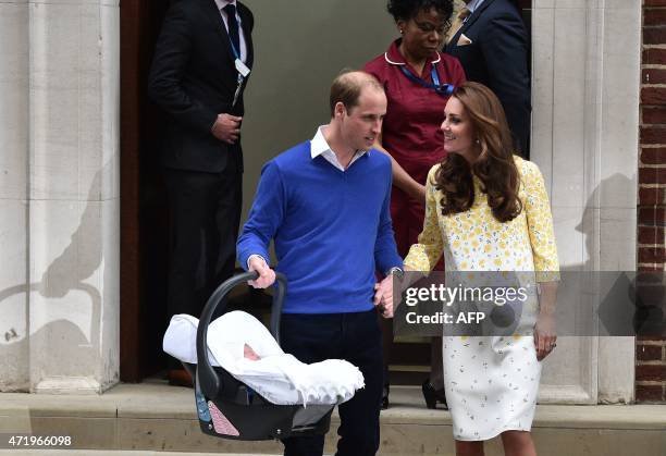 Britain's Prince William, Duke of Cambridge, carries his newly-born daughter, his second child, in a car seat as he walks with his wife Catherine,...