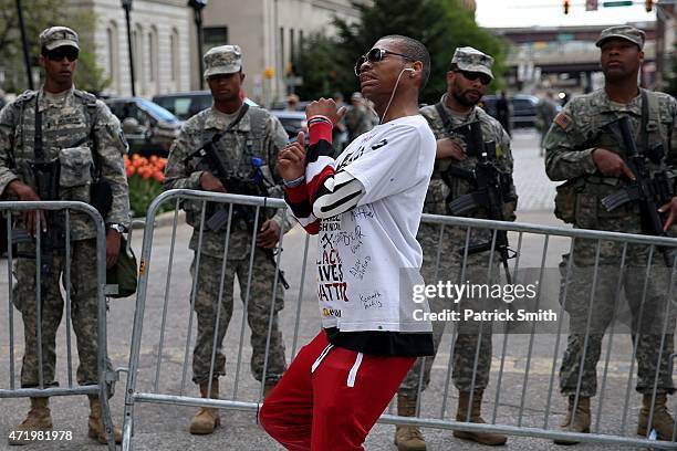 Man dances in front of National Guard as protesters congregate at City Hall a day after Baltimore authorities released a report on the death of...